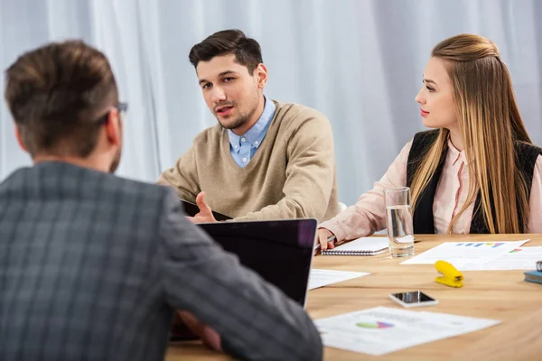 Partial view of young business people at workplace during business meeting in office — Stock Photo