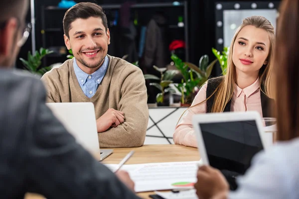 Вибірковий фокус усміхнених бізнес-колег під час ділової зустрічі з партнерами в офісі — стокове фото