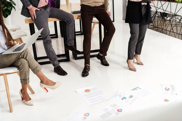 Partial view of multicultural group of marketing managers with papers on floor in office — Stock Photo