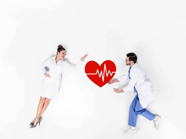 Creative collage of male and female doctors with heartbeat sign on white — Stock Photo