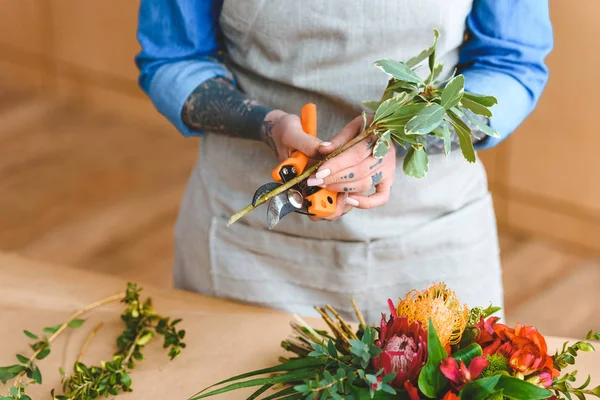 Section médiane du jeune fleuriste dans les usines de découpe de tablier sur le lieu de travail — Photo de stock