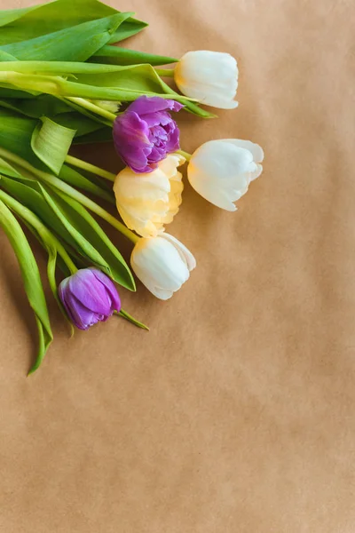 Vista superior de hermosos tulipanes coloridos sobre papel artesanal - foto de stock