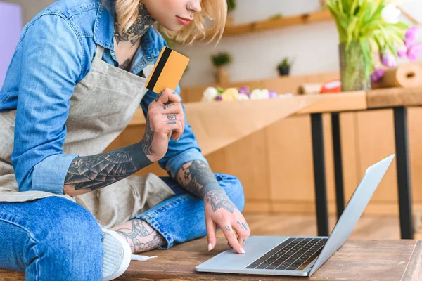 Schnappschuss eines jungen Blumenhändlers mit Kreditkarte und Laptop — Stockfoto