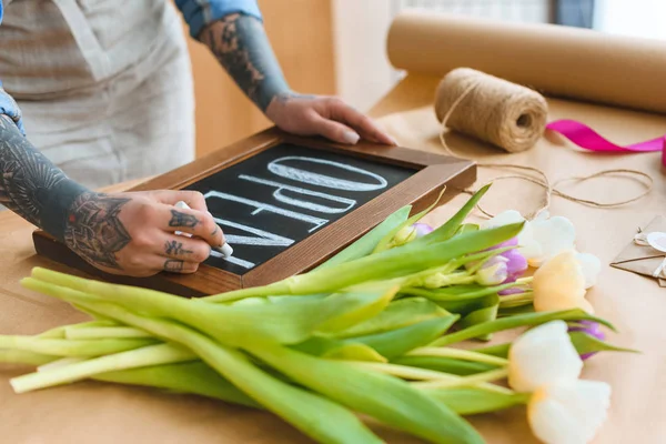 Cropped shot of florist writing word open on board in flower shop — Stock Photo