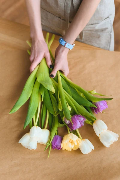 Recortado tiro de floristería sosteniendo hermosas flores de tulipán - foto de stock