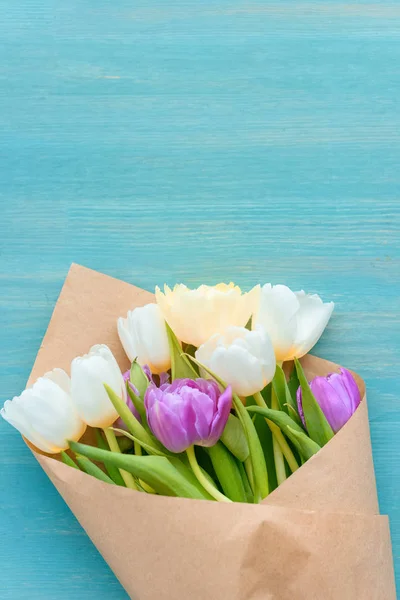 Vista dall'alto di bellissimo bouquet di tulipani in carta artigianale su superficie di legno turchese — Foto stock