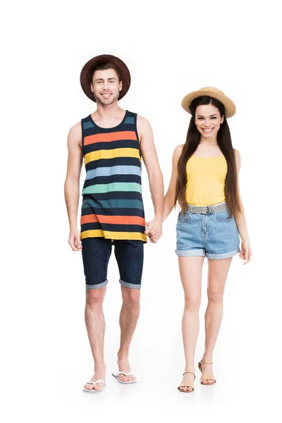 Alegre pareja en gafas de sol y sombreros cogidos de la mano, aislados en blanco - foto de stock