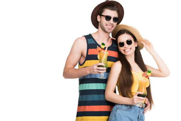 Smiling couple in sunglasses and hats holding summer cocktails, isolated on white — Stock Photo