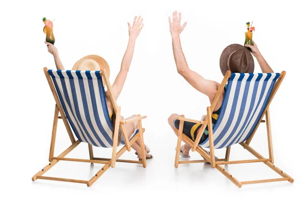 Vista trasera de pareja relajándose en sillas de playa con cócteles, aislado en blanco - foto de stock