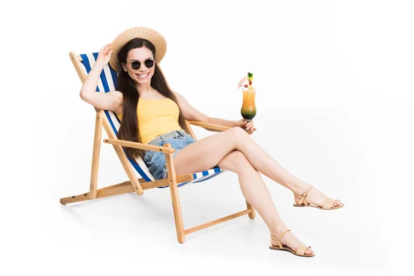 Belle fille en lunettes de soleil reposant sur chaise de plage avec cocktail, isolé sur blanc — Photo de stock