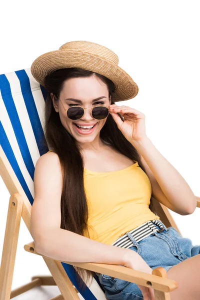 Hermosa chica feliz en gafas de sol guiño y relajarse en la silla de playa, aislado en blanco - foto de stock