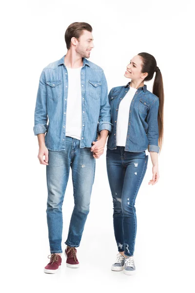 Young cheerful couple holding hands and looking at each other, isolated on white — Stock Photo