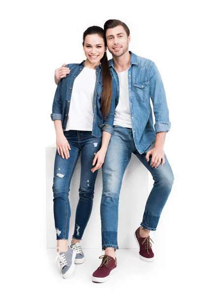 Abbraccio sorridente coppia in jeans, isolato su bianco — Foto stock