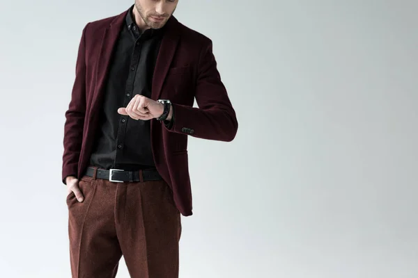 Cropped view of stylish man in suit looking at wristwatch, isolated on grey — Stock Photo