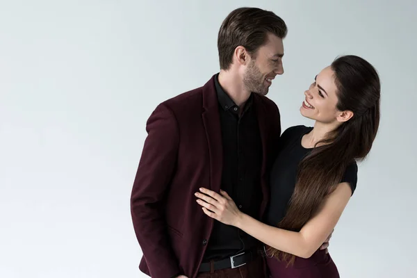 Beau couple souriant étreignant, isolé sur gris — Photo de stock