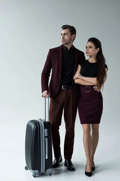 Casal sério com bagagem pronta para viagem, isolado em cinza — Fotografia de Stock