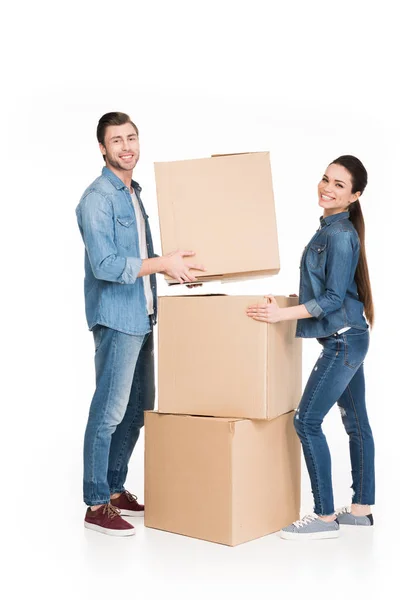 Heureux jeune couple se déplaçant avec des boîtes en carton, isolé sur blanc — Photo de stock