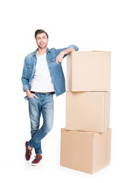 Smiling young man with carton boxes, isolated on white — Stock Photo
