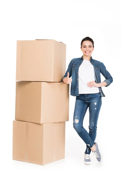 Жінка з картонними коробками, що показує великий палець вгору, ізольована на білому — стокове фото