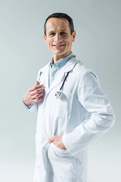 Schöner erwachsener Arzt mit Stethoskop, der auf grau isoliert in die Kamera blickt — Stockfoto