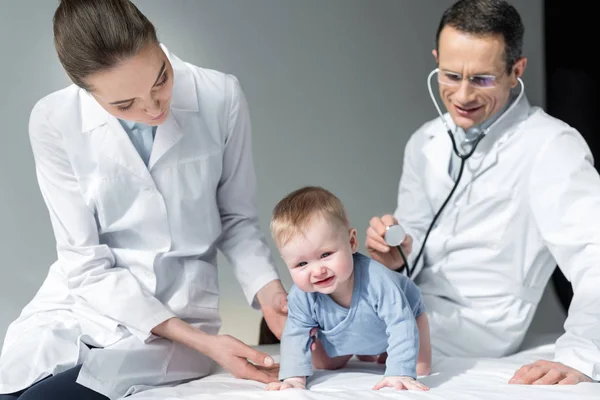 Pediatricians trying to check breath of sad baby — Stock Photo