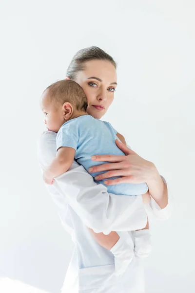 Schöne Kinderärztin trägt kleines Baby isoliert auf weiß — Stockfoto