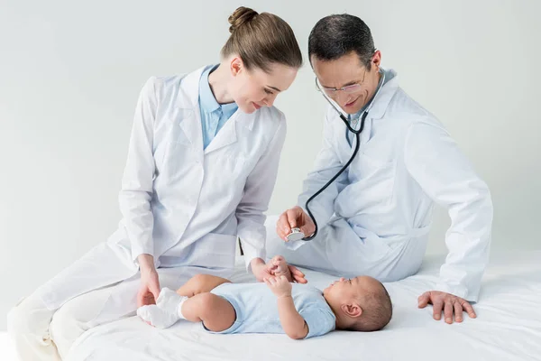 Confident pediatricians listening breath of little baby with stethoscope — Stock Photo