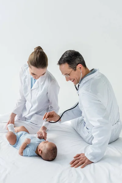 Pediatras ouvindo respiração de bebê pequeno com estetoscópio — Fotografia de Stock