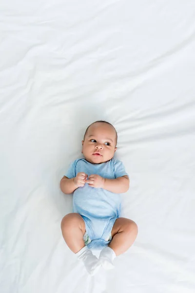 Blick von oben auf entzückendes kleines Kind, das auf dem Bett liegt — Stockfoto