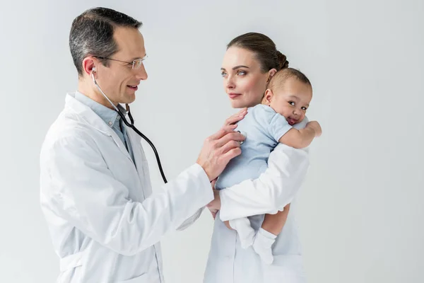 Pediatras examinando pouco hálito do bebê isolado no branco — Fotografia de Stock