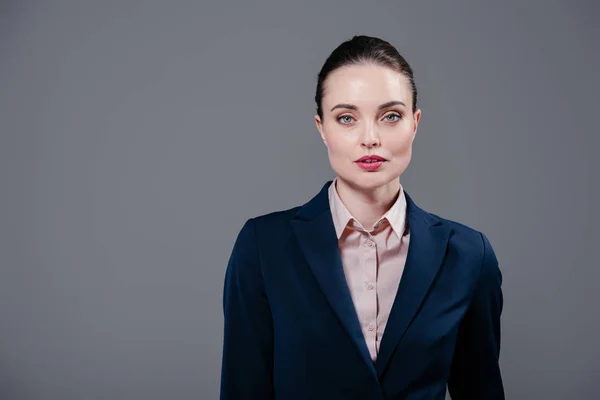 Ernsthafte erwachsene Geschäftsfrau blickt in Kamera isoliert auf grau — Stockfoto