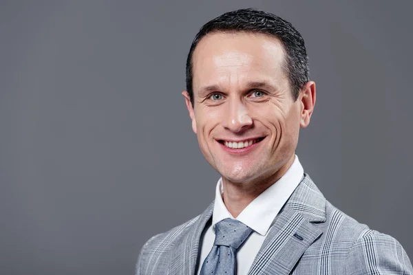 Happy adult businessman in grey suit looking at camera isolated on grey — Stock Photo