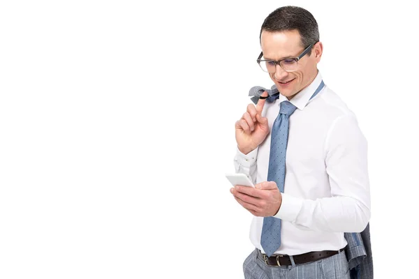 Улыбающийся взрослый бизнесмен, использующий смартфон, изолированный на белом — стоковое фото