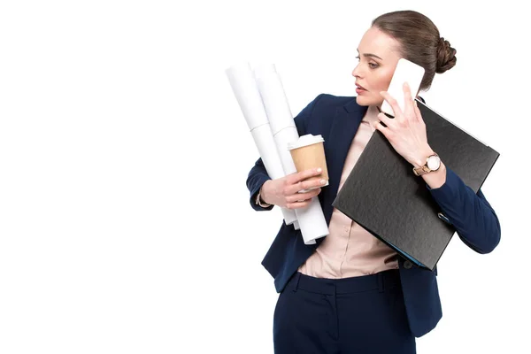 Overworked adult businesswoman with lot of paperwork and coffee to go talking by phone isolated on white — Stock Photo