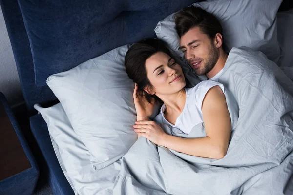 Casal romântico deitado na cama em seu quarto — Fotografia de Stock