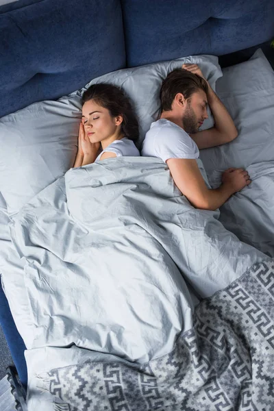 Dormir hombre y mujer acostados en la cama - foto de stock