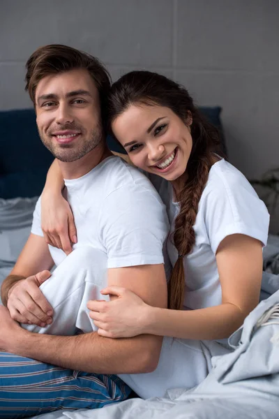 Homme et femme souriants embrassant tendrement dans la chambre — Photo de stock