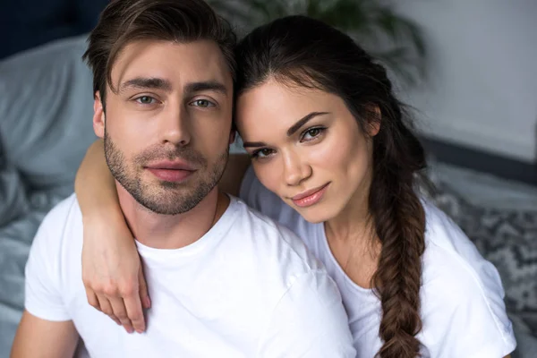 Attractive woman embracing her husband in bedroom — Stock Photo