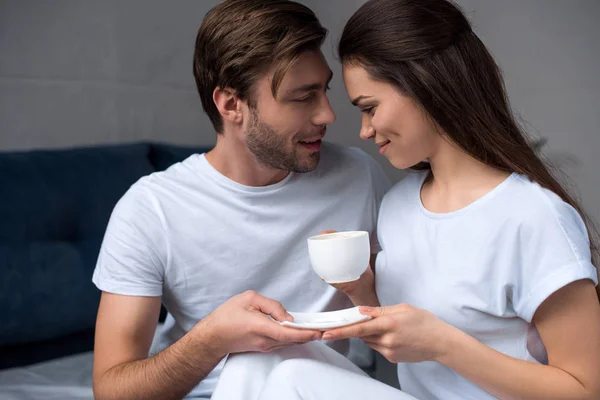 Beau jeune couple buvant du café au lit — Photo de stock