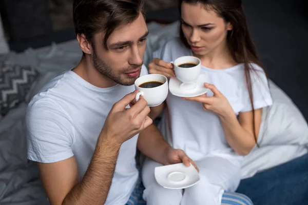 Bärtiger Mann und attraktive brünette Frau trinken Kaffee im Bett — Stockfoto