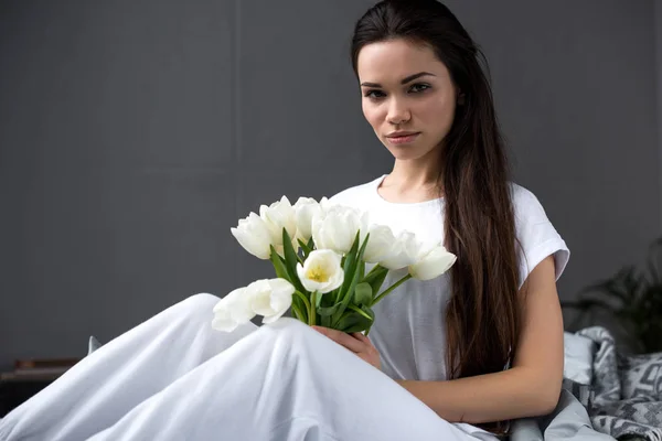 Menina bonita com buquê branco na cama — Fotografia de Stock