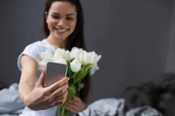 Brünettes Mädchen macht Selfie von sich mit weißen Tulpen — Stockfoto