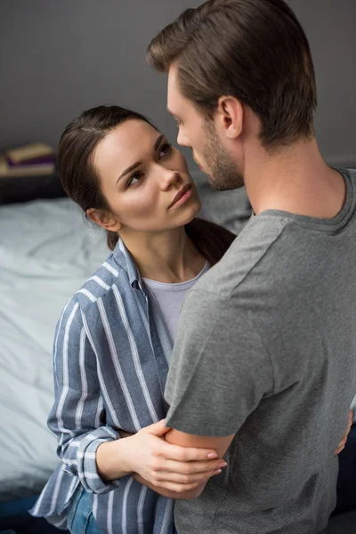 Frau umarmt und sieht ihren Mann im Schlafzimmer an — Stockfoto