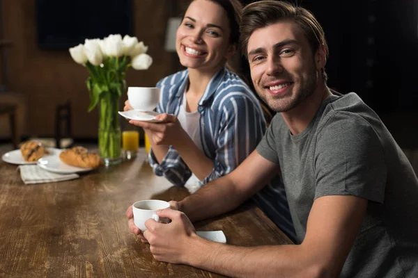 Sorrindo esposa e marido bebendo café na cozinha — Fotografia de Stock