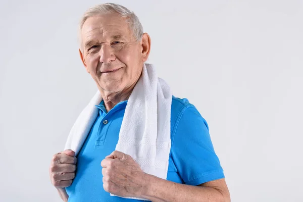 Portrait of smiling senior man with towel looking at camera isolated on grey — Stock Photo