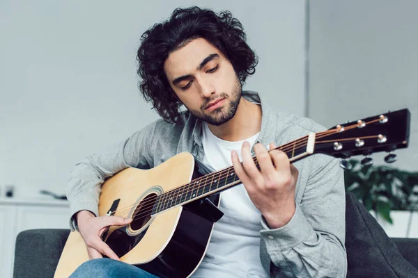 Guitarrista guapo serio tocando la guitarra acústica en casa — Stock Photo