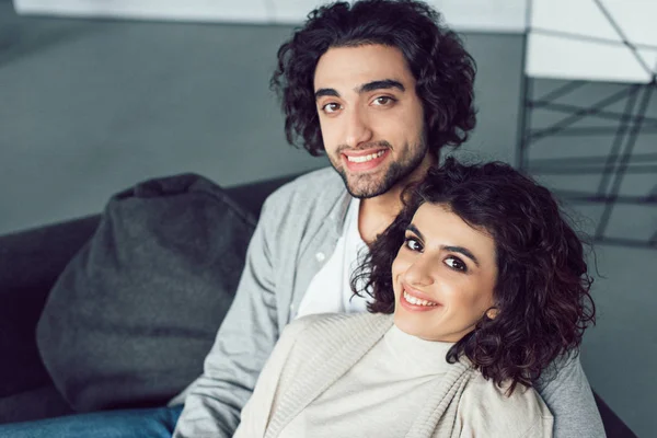 Ritratto di giovane coppia sorridente che guarda la macchina fotografica a casa — Foto stock
