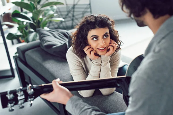 Boyfriend playing guitar for attractive girlfriend at home — Stock Photo