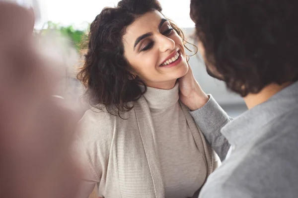 Boyfriend cuddling smiling girlfriend at home — Stock Photo