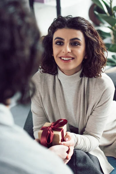 Image recadrée de petit ami présentant cadeau à la petite amie à la maison — Photo de stock